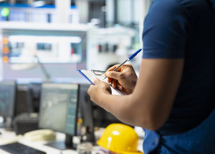 Solar panel manufacturing plant researcher taking notes on files, developing new solar energy systems prototypes. Engineer inspecting new photovoltaics materials, writing down info.